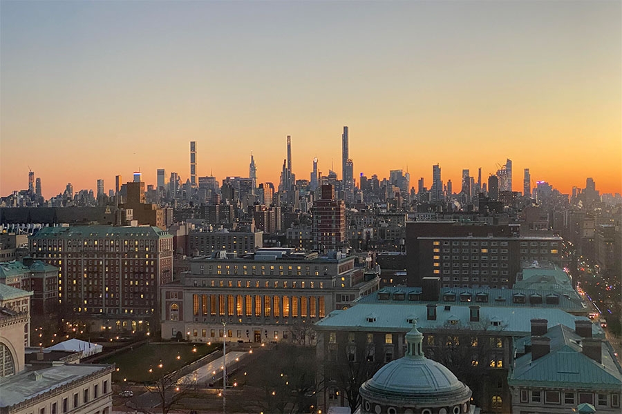 View of Columbia's campus at sunset with NYC skyline in the distance