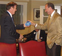 Dean Quigley accepts gift from Evan Miller